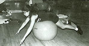 A member of Equinox's Surf Flex workout class balances on a large inflated ball.